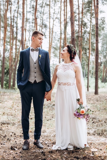 Braut und Bräutigam umarmen sich, küssen sich draußen an einem Hochzeitstag, junges Paar, Valentinstag