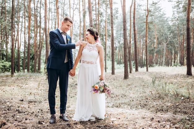 Braut und Bräutigam umarmen sich, küssen sich draußen an einem Hochzeitstag, junges Paar, Valentinstag