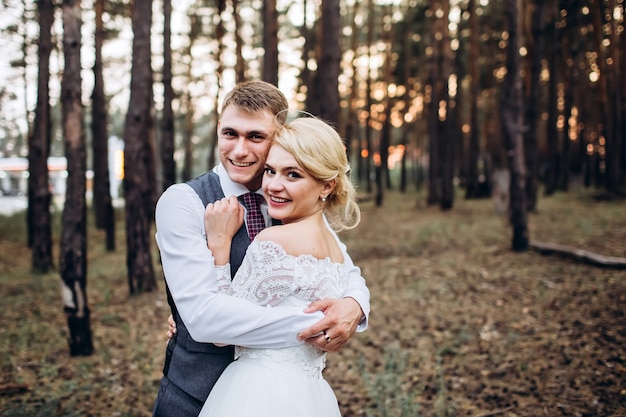 Braut und Bräutigam umarmen sich, küssen sich draußen an einem Hochzeitstag, junges Paar, Valentinstag