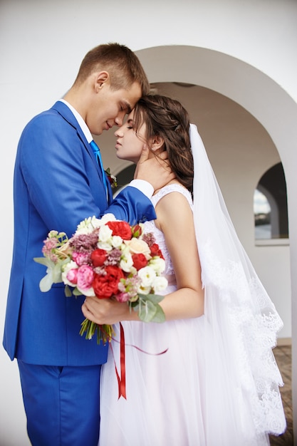 Braut und Bräutigam umarmen und küssen sich bei der Hochzeit