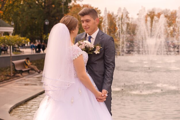 Braut und Bräutigam zusammen in der Nähe des Brunnens freuen sich an ihrem Hochzeitstag