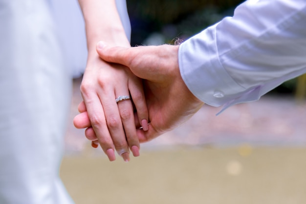 Braut- und Bräutigamhändchenhalten in Hochzeit celemony.