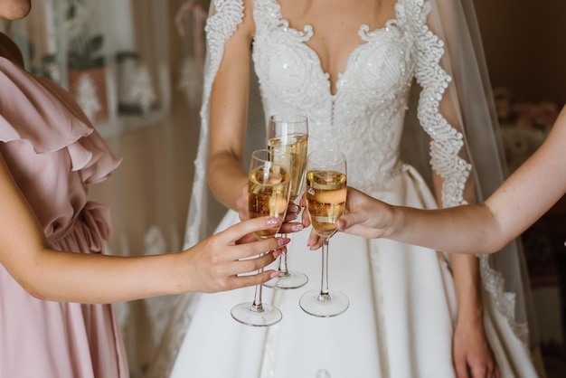 Braut und Brautjungfer trinken Champagner am Hochzeitstag