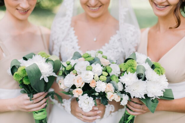 Braut und Brautjungfern halten Blumensträuße Nahaufnahme