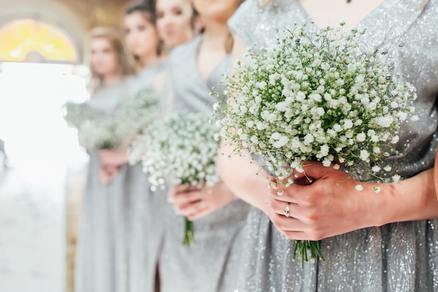 Brautjungfern halten Blumen in ihren Händen