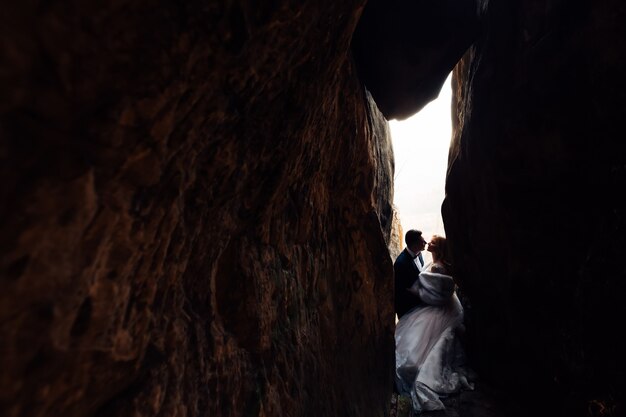 Brautpaar in festlicher Kleidung wollen sich in einer Steintunnelhochzeit küssen