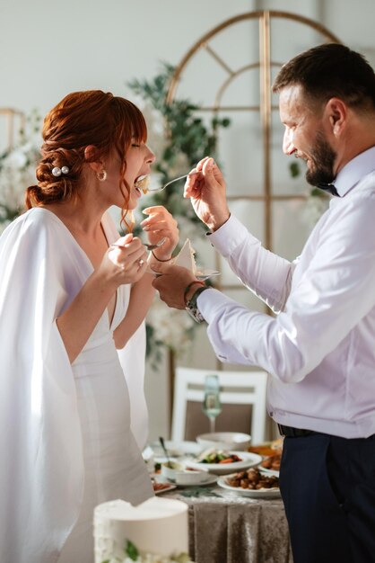 Brautpaare schneiden und probieren glücklich die Hochzeitstorte