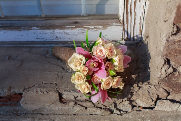 Brautstrauß von rosa Blumen auf altem Backsteinhintergrund