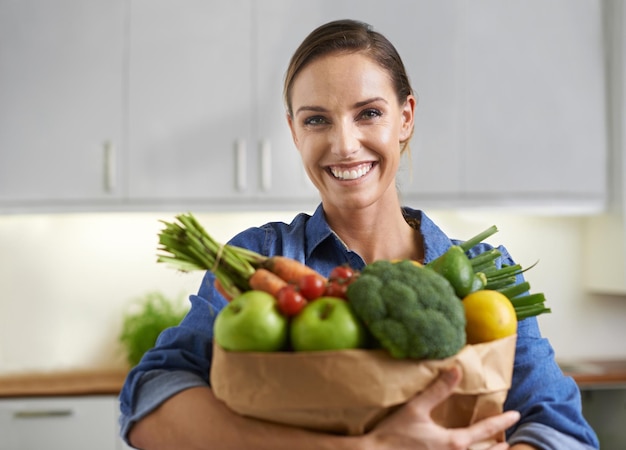 Brazadas de nutrición Una mujer joven con verduras en la cocina