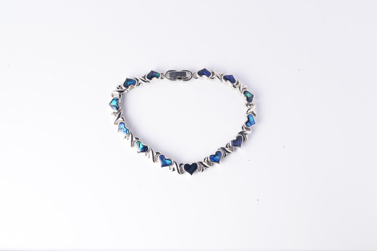 Un brazalete hecho de plata y concha de abelón en forma de corazón o perla madre
