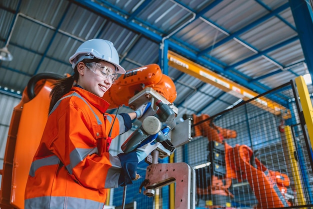 Foto brazo de montaje de robot de control de programación de trabajador de ingeniero inteligente en fábrica moderna de industria metalúrgica