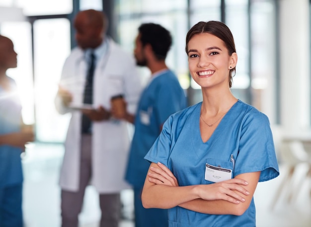 Brazos cruzados médico y retrato de enfermera en el hospital con equipo para la integridad en el que puede confiar atención médica confiada y sonrisa con feliz mujer profesional de medicina en trajes de cirugía en la clínica para el tratamiento
