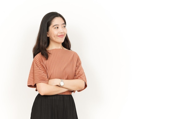 Brazos cruzados y sonrisa de hermosa mujer asiática aislado sobre fondo blanco.