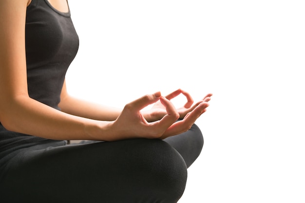 brazos femeninos y piernas cruzadas durante la meditación aislada
