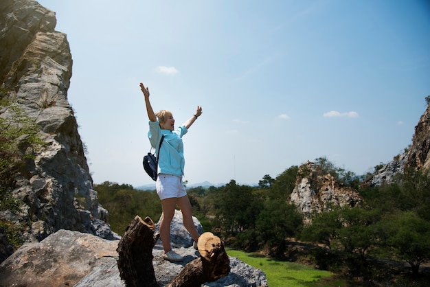 Brazos de mujer extendidos sobre una roca de montaña