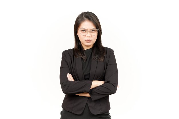 Brazos plegados y cara enojada de hermosa mujer asiática con chaqueta negra aislada en blanco