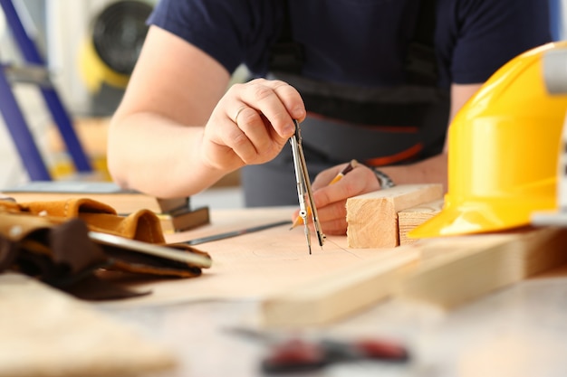 Los brazos del trabajador que hacen el plan de la estructura en el primer de papel escalado. Trabajo manual DIY inspiración mejora trabajo reparación tienda gráfico carpintería inicio lugar de trabajo idea diseñador carrera barra de madera regla