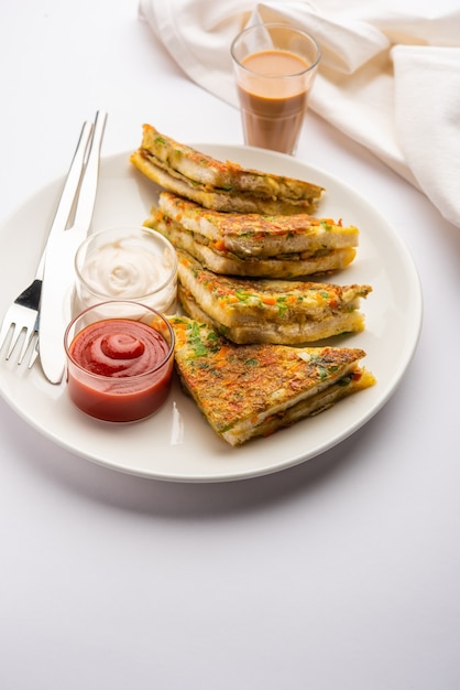 Bread Omelette é um café da manhã rápido e fácil da Índia. Fatias de pão fresco mergulhadas na massa de ovo com especiarias e fritas rasas. servido com ketchup de tomate e chá