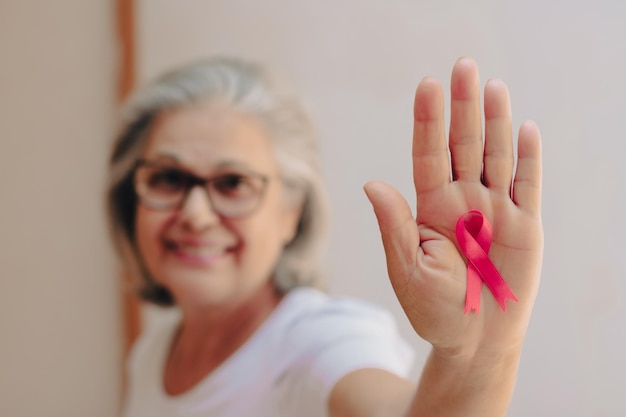 Breast Cancer Awareness Month Bild Reife weiße Frau mit rosa Schleife isoliert