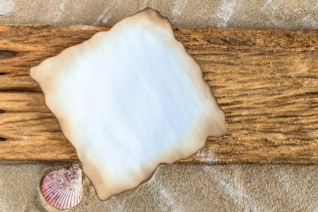 Foto brennen sie altes braunes papier mit rändern auf hölzernem auf dem strandhintergrund.