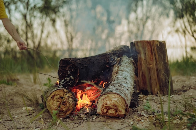 Brennende Holzscheite am Lagerfeuer, lokales Reisekonzept