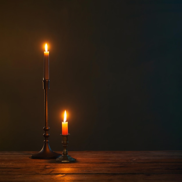 Brennende Kerzen in Vintage-Kerzenhaltern auf dunklem Hintergrund