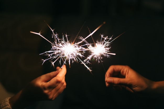 Brennende Neujahrswunderkerze. Bengalisches Licht, das in kleine Glitzer streut.