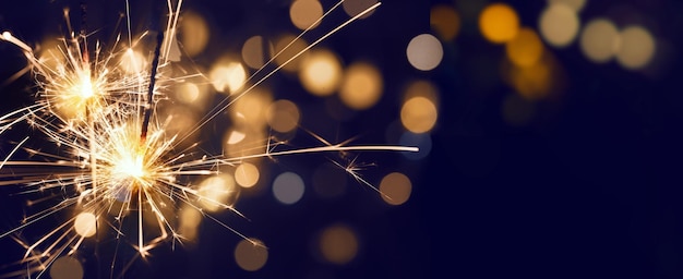 Brennende Weihnachtswunderkerze mit Bokeh-Hintergrund. Hintergrund der frohen Weihnachten und des guten Rutsch ins Neue Jahr.