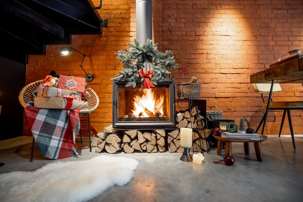 Brennender Kamin dekoriert mit Geschenken und Neujahrskranz in gemütlicher Wohnlandschaft