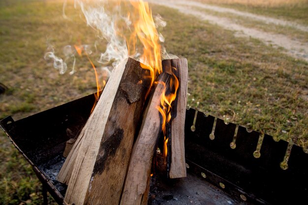 Brennendes Feuer auf dem Campingplatz vor Sonnenuntergang