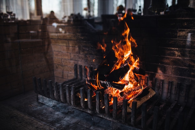 Brennendes Holz mit heller Flamme und Funken gegen dunklen Hintergrund