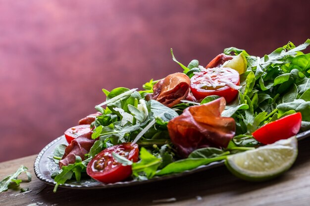 Bresaola de carne seca. Salada bresaola rúcula bebê espinafre tomate limão e queijo parmesão.