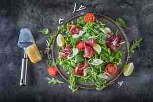 Foto bresaola de carne seca salada de bresaola rúcula espinafre bebé tomates limão e queijo parmesão