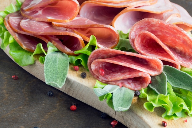 Brett mit Prosciutto, Speck, Salami und Würsten auf hölzernem Hintergrund. Aufschnitt.