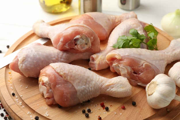 Brett mit rohem Hühnerfleisch und Gewürzen, Nahaufnahme. Huhn kochen