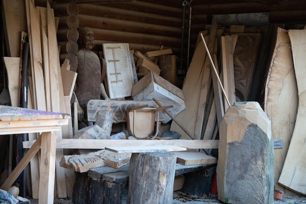 Bretter und Holz in einer Schreinerei draußen. Holzrohlinge an der DIY-Werkbank. Hobbyhandwerk.