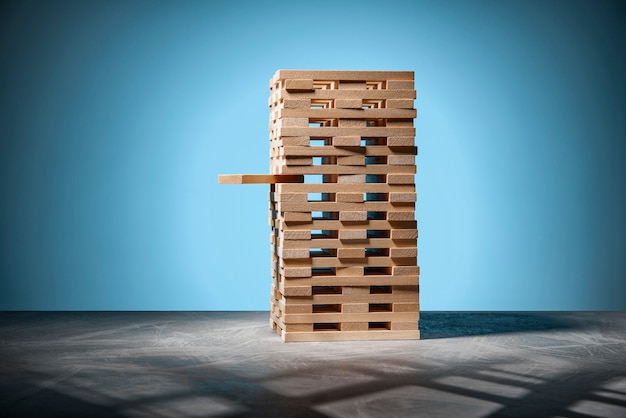 Brettspiel Jenga, ein Turm aus Holzklötzen auf Blau