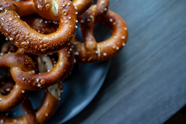 Brezeln mit Salz in einem Teller auf einem strukturierten Holztisch Traditionelles Essen Oktoberfest