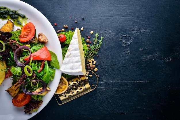 Foto brie-käse mit gegrilltem gemüse draufsicht freier platz für text auf einem hölzernen hintergrund