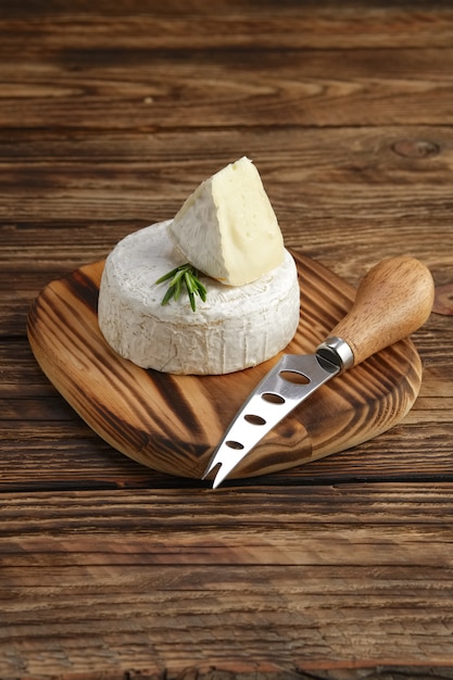 Brie oder Camembert auf Holzbrett mit Messer für Weichkäse