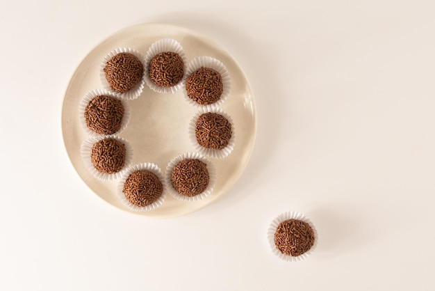 Brigadeiro bolas de trufa de chocolate brasileño dulces y copos de chocolate vista aérea fondo limpio