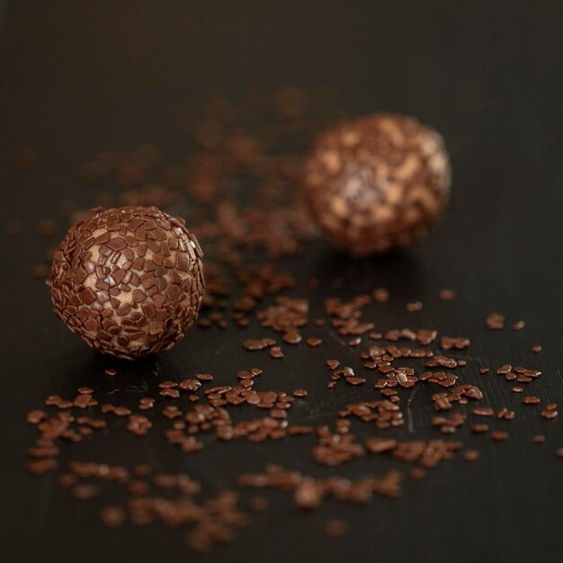 Brigadeiro de chocolate con leche dulce brasileño con salpicaduras de chocolate sobre un fondo negro