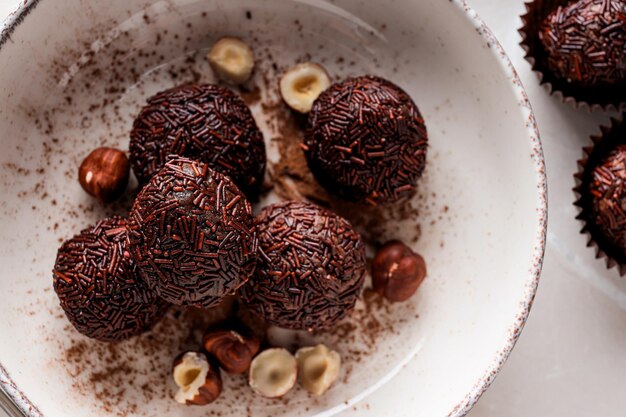 Brigadeiro e avelãs em tigela na vista superior de fundo branco