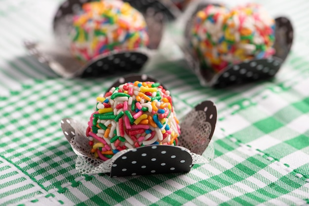 Brigadeiros hermosos dulces coloridos en un mantel verde y blanco enfoque selectivo