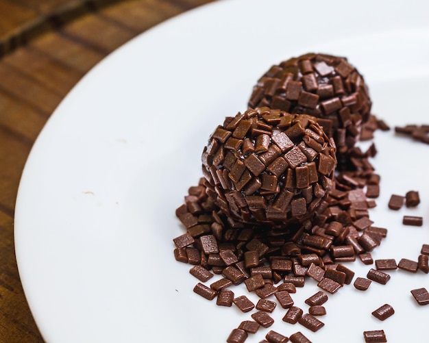 Brigadeiros isolados em um prato branco.