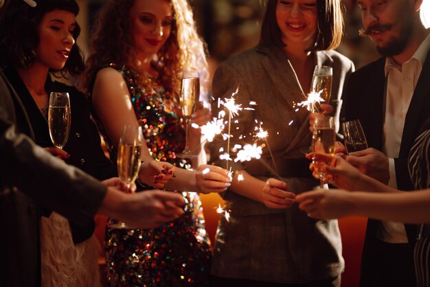 Foto brilhantes nas mãos jogando fogos de artifício para celebrar as férias de inverno magic new year