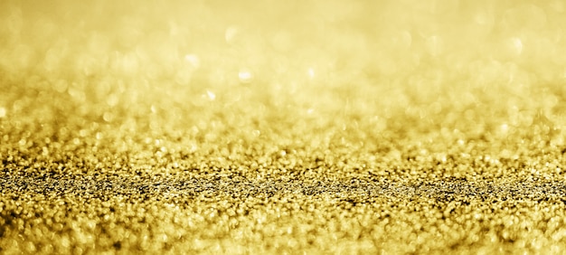 Brilho abstrato de glitter dourado desfocado com bokeh