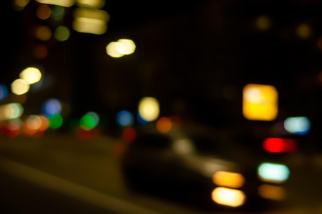 Brilho da luz dos faróis do carro Imagem desfocada da luz das lâmpadas de rua e faróis do carro