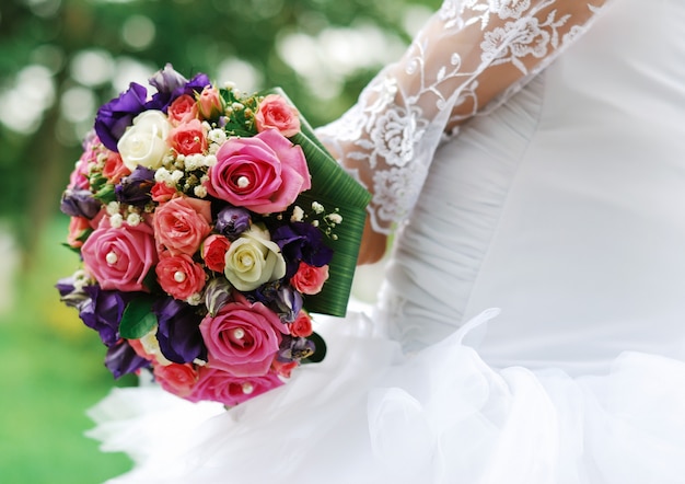 Foto brillante hermoso ramo de novia rosa y morado de la novia en la mano