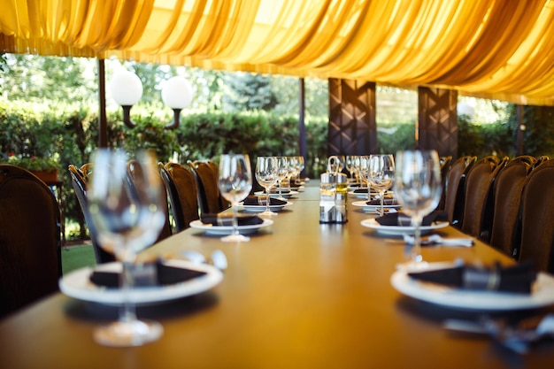 Brillantes cristalería se alza sobre una larga mesa preparada para la cena de bodas